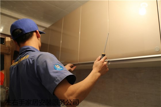 櫥柜安裝師傅正在檢查吊柜門板 櫥柜安裝師傅正在檢查吊柜門板